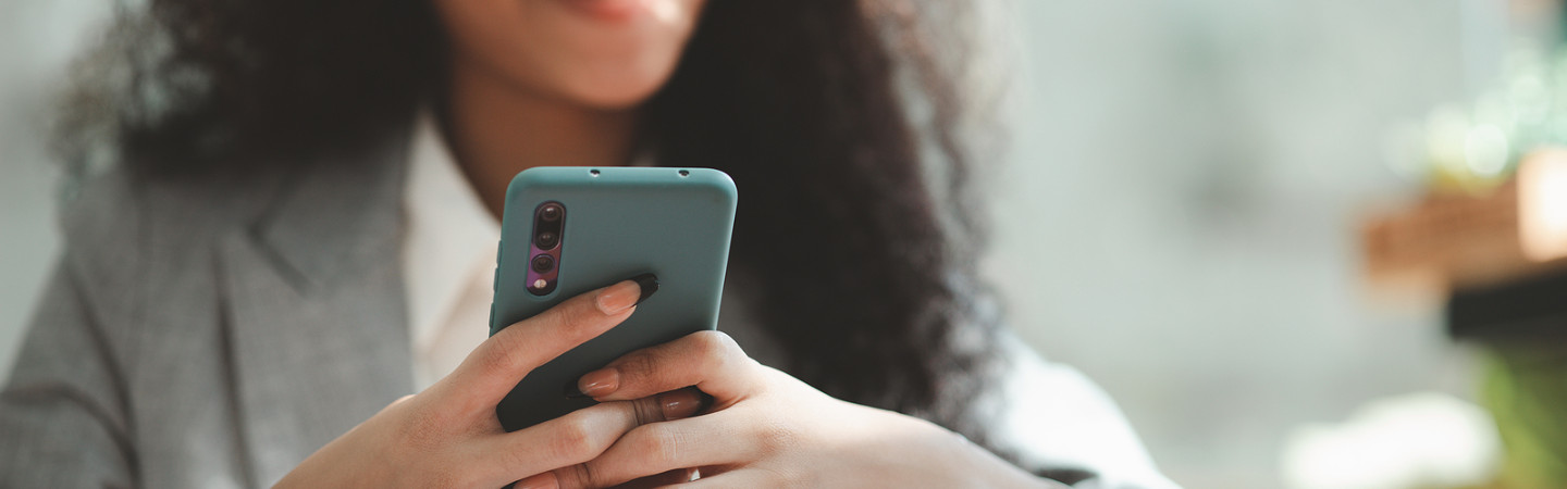 young lady wearing suit using her smartphone