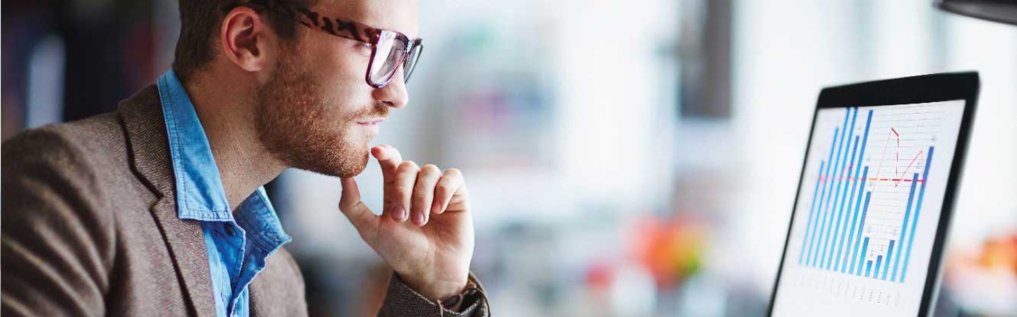 man with reading glasses looking at his computer monitor