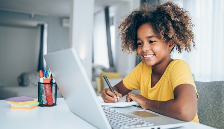 little girl looking at her laptop