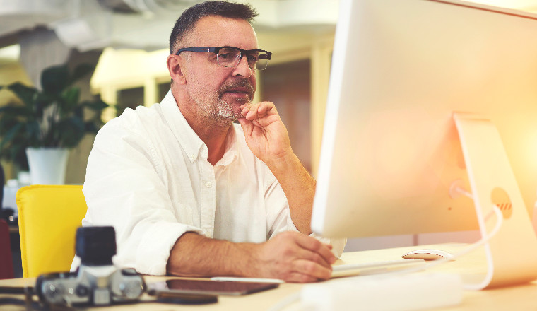 Older man sitting at his desktop computer