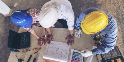 three construction workers reviewing plans