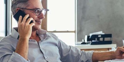 man with glasses on mobile phone