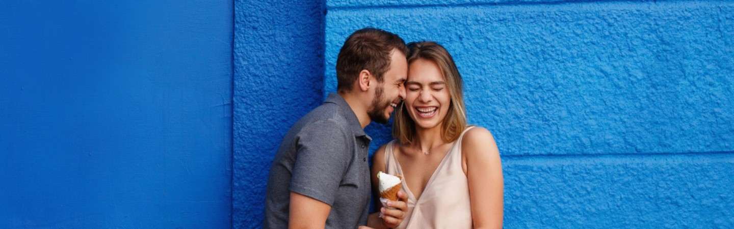 a young couple in front of a blue wall