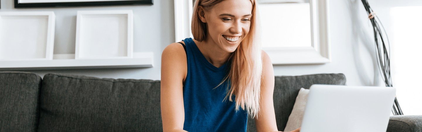 a woman sitting on her couch working on her laptop