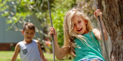 two kids swinging