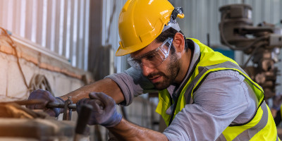 Man in hard hat working at machine