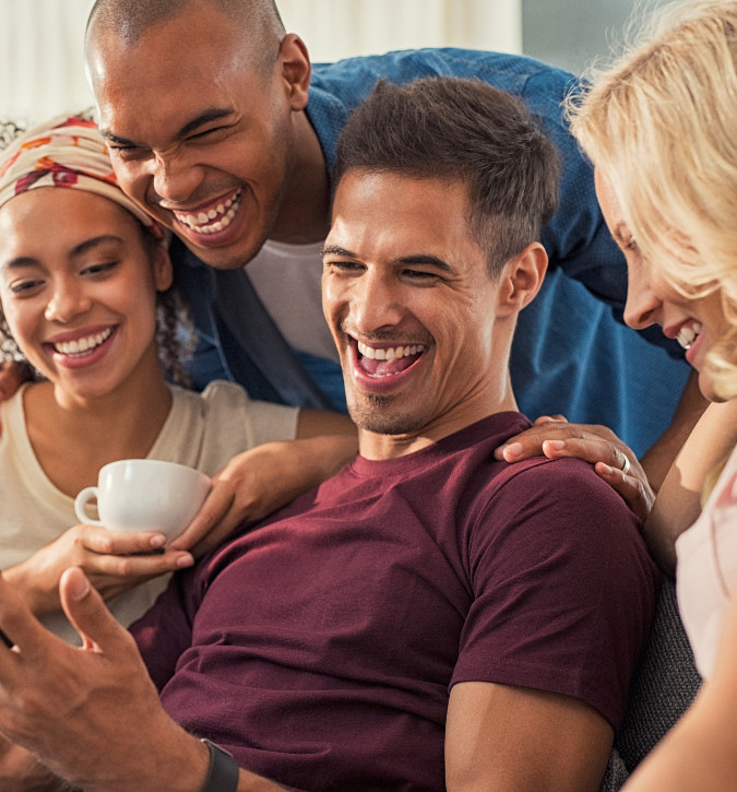 two couples smiling and laughing while drinking coffee