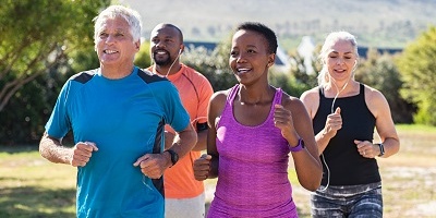 Group of four mature adults jogging in the park