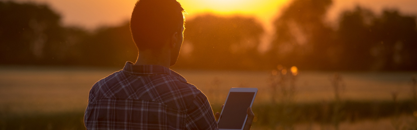 a man holding a tablet outside