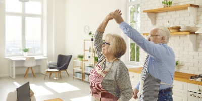 an elderly couple dancing in their kitchen